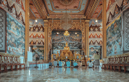 Samut Songkram, Thailand Apr 3, 2023 - Many people are sitting pay respect to The golden buddha...
