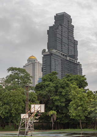 Basketball wooden backboard with the hoop metal ring and the white net are against the modern building in the city park. Space for text, Selective focus.の写真素材