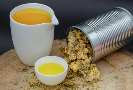 Chinese chrysanthemum flower tea and Dried chrysanthemum flower on wooden cutting board. Healthy beverage for drink. Herbs and medical concept. Space for text, Selective focus.の写真素材