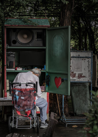 Bangkok, Thailand - 22 Sep, 2023 - The old grey-haired man is controlling and playing the musical instrument in the park for entertaining people who come to relax and workout. Selective focus.の写真素材