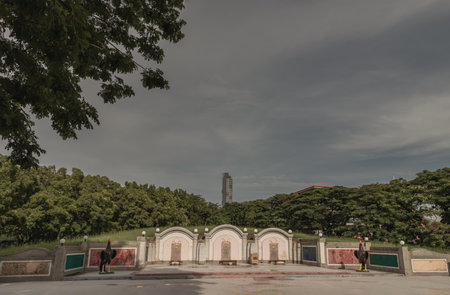 Bangkok, Thailand - 22 Sep, 2023 - Three Traditional chinese graves are at Chinese cemetery are against the modern building and sky background. A rows of stone tombstones is in the graveyard, Space for text, Selective focus.のeditorial素材