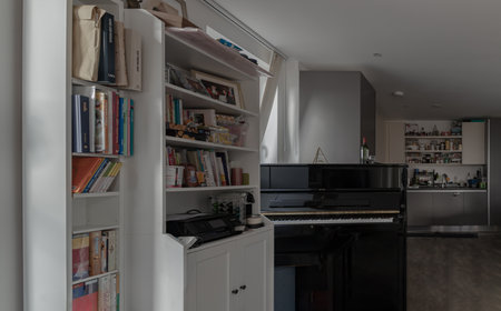 London, UK - Oct 21, 2023 - Living room interior with White bookcase, Automatic coffee machine on white wooden shelf and Black piano. Lifestyle, Space for text, Selective focus.のeditorial素材