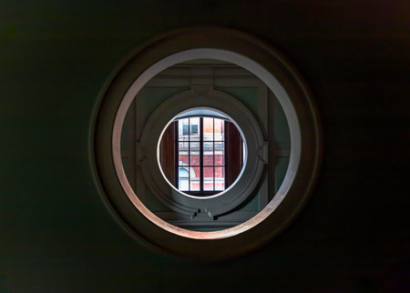London, UK - Nov 01, 2023 - Perspective view of Round Shape Window in a green room at the Victoria and Albert Museum. Abstract interior background with round window glass on green wall, Space for text, Selective Focus.のeditorial素材
