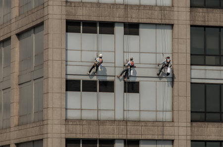 Group of workers cleaning windows service on high rise office building. Selective focus.の写真素材