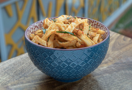 Spicy Stir-fried Pork belly with Preserved Bamboo shoot in ceramic bowl on wooden table. Space for...