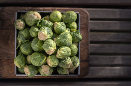 Top view of Fresh raw organic Green brussel sprouts vegetable on Wooden cutting board with Natural sunlight. Uncooked brussels sprouts, View from above, Copy space, Selective focus.の写真素材