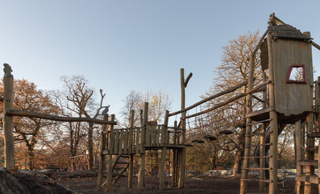 The Children's playground with Slide, Rope Net Bridge made of Wooden Tree trunk in acton park. Empty outdoor playground with wooden equipment for children, Copy space, Selective focus.の写真素材