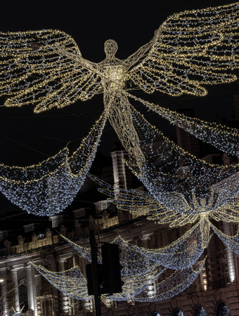 London, UK - Dec 25, 2023 - Flying angel Christmas decoration led lights display. Dramatic view of the traditional Christmas decoration lights hanging above Regent Street during dusk, The Spirit of Christmas, Light Festival in London, Space for text, Seleのeditorial素材