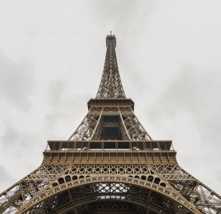 France, Paris - Jan 4, 2024 - Low angle shot of Famous Eiffel tower iron structure with white sky background. Architectural detail design of the Eiffel tower in Paris. Paris Best Destinations in Europe, Space for text, Selective focus.のeditorial素材