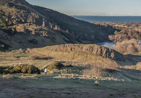 Scenic landscape of Holyrood Park on Salisbury Crags with cityscape of Edinburgh city. Space for text, Selective focus.の写真素材