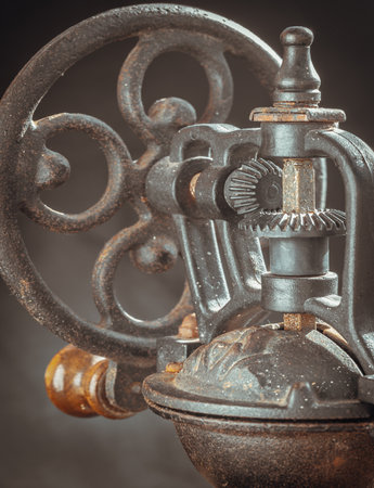 Detail of Antique coffee bean original grinder metal shake wheel with hand crank. Close-up of Old original coffee grinder, Space for text, Selective focus.の写真素材