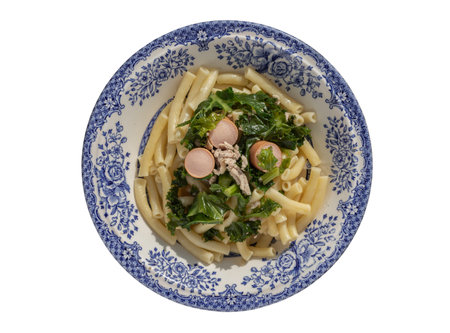 Plate of Penne pasta with Sausage, Pork and Kale isolated on white background with clipping path. Top view, Selective Focus.の写真素材