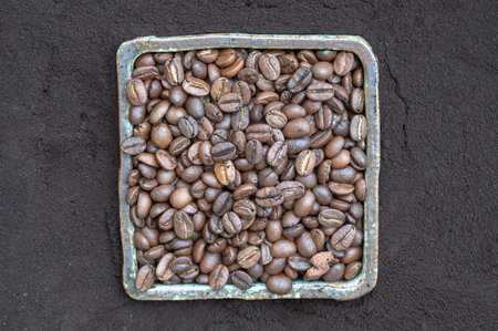 Coffee beans in ceramic square bowl with Coffee powder background. lternative coffee for living life, Coffee concept, Space for text, Selective focus.の写真素材