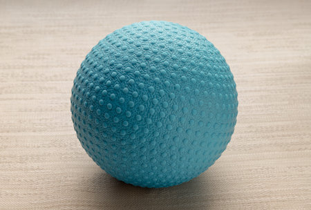 Lacrosse massage ball on sofa cushions. Blue rubber lacrosse ball, Spherical ball, Space for text, Selective focus.の写真素材