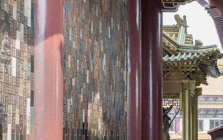 Bangkok, Thailand - Apr 11, 2024 - Golden gable roof and slab of colored tiles on temple wall at Fo Guang Shan Thaihua Temple. Architecture exterior of Taiwanese temple style, Space for text, Selective focus.のeditorial素材