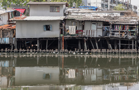Bangkok, Thailand - Apr 20, 2024 - In slum area, the houses are old along the Khlong Phra Khanong. Broken houses are beside the Canal with dirty water. Bad pollution problem, Copy space, Selective focus.のeditorial素材