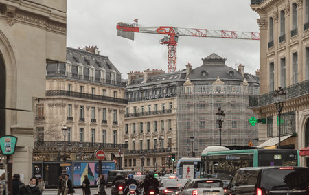 France, Paris - Jan 04, 2024 - Paris street view of Avenue de l Opera with traditional french building facades and construction crane, A fine building housing Royal Air Maroc and Berlitz near the Opera Garnier. Space for text, Selective focus.のeditorial素材