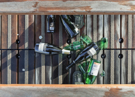 France, Paris - Jan 03, 2024 - Top view of The beer and wine bottles were left on the floor next to the wooden benches on Pont des arts.のeditorial素材