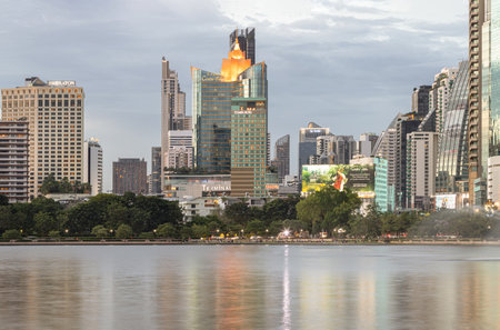 Bangkok, Thailand - 22 Jun, 2024 - Cityscape office buildings with modern architecture with reflection on the surface of water. Picturesque view of skyscrapers and dramatic sky before sunset, Space for text, Selective focus.のeditorial素材