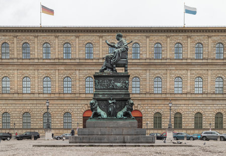 Munich, Germany - Dec 21, 2023 - Side view of Monument Bronze Statue of King Maximilian I Joseph of Bavaria with The Munich Residence Museum Building at the Max Joseph Square in central Munich. Space for text, Selective focus.のeditorial素材