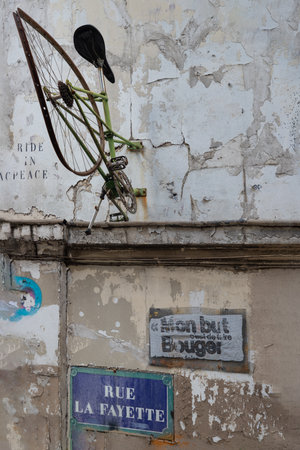 France, Paris - Jan 03, 2024 - Ride in Peace on rue la fayette. Sculptures bicycle art installed on wall decor old building, Urban intervention art, Paris street artwork, Paris wall art, Space for text, selective focus.のeditorial素材
