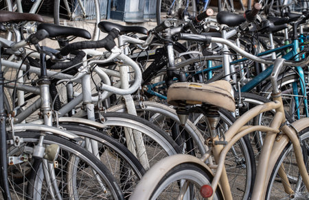 A lot of old bicycles different brand names parked on the street. Row of Bicycles parked in front of...