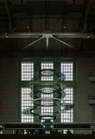 London, UK - Oct 13, 2023 - Hanging spiral art installation outside Lift 109 at Art Deco Turbine Hall A, inside refurbished Battersea Power Station Interior, The decorative lighting pendants and Oculi at the chimney Lift 109 experience (imitating the liftのeditorial素材