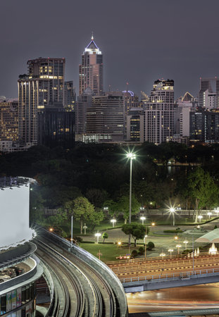 Bangkok, Thailand - 31 Dec, 2022 - BTS Sky railway tracks and Intersection bridge pass through in downtown with traffic on the street below in central business district with bright glowing lights at night and skycrapers building of Bangkok in the backgrouのeditorial素材