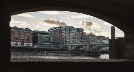 London, UK - Nov 07, 2023 - View of Southwark Bridge (formerly known as Queen Street Bridge) cross The River Thames with Modern buildings in the background at city of london. Looking through the tunnel under the bridge, Selective focus.のeditorial素材