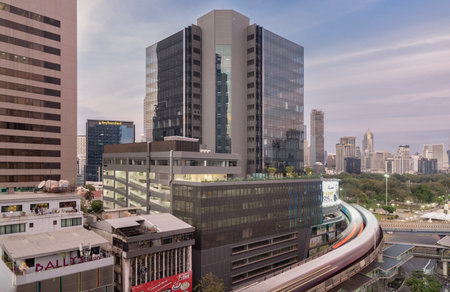 Bangkok, Thailand - 31 Dec, 2022 - BTS Sky railway tracks and Intersection bridge pass through in downtown with traffic on the street below in central business district at daytime with skycrapers building of Bangkok in the background. Transportation and tのeditorial素材