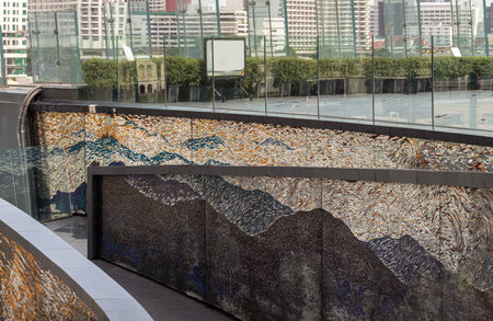 Bangkok, Thailand - 28 Sep, 2024 - A sloping walkway leading down to a park in a high-rise building with cladding in the shape of an arch are decorated with colorful Stained glass scraps mosaic. Copy space, Selective focus.のeditorial素材
