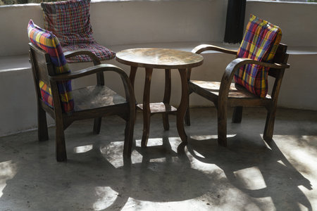 Two wooden chairs with seat cushion and Rouhd table in Relaxing corner on morning sun. use it as...