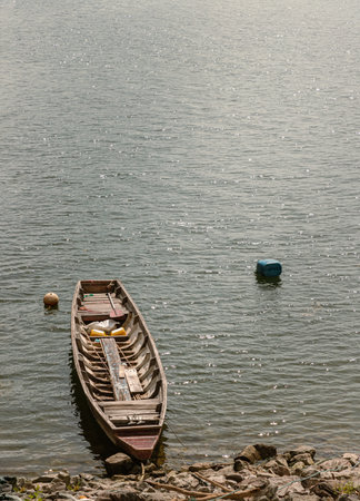 Traditional hand built small wooden rowboat slowly in warm evening light was resting along in the dam. use it as your Wallpaper, Poster and Space for text, Selective focus.の写真素材