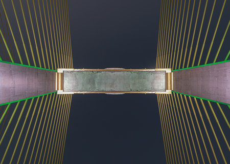 Looking up view of a cable-stayed bridge with evening sky in the background. Suitable for wallpaper, poster and space for text. Selective focus.の写真素材