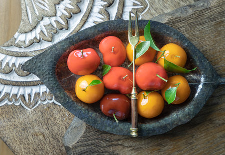 Top view of imitation fruits (Kanom look choup) in the shape of oranges, rose apple and strawberries has a sweet taste. Traditional thai sweet treats made from mung beans and coconut milk, and glazed in shiny agar agar jelly, use it as your Wallpaper, Poster and Copy space, Selective focus.の写真素材