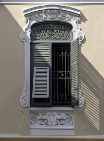 Bangkok, Thailand - Mar 02, 2025 - The Sunlight shines through Wooden louvered window shutters on cement wall of The Bang Khun Phrom is a magnificent. early 20th century European style palace in neo-Baroque / Rococo style combined German Art Nouveau style, Selective focus.の写真素材