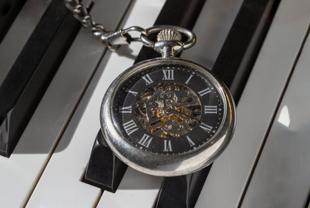 London, UK - Apr 19, 2025 - Antique pocket watch or Retro pocket watch on Piano keys background....