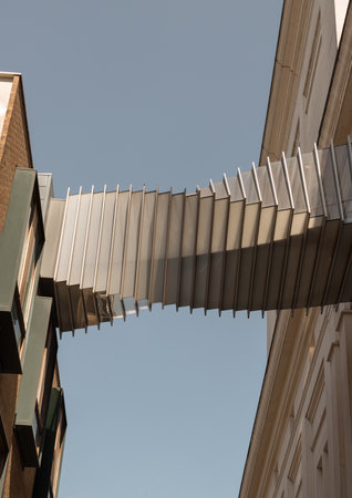 London, UK - May 13, 2025 - Looking up of Bridge of Aspiration with sky background, The futuristic modern of Twisted sky bridge connecting Royal opera house to Royal ballet school in Covent garden, Exterior architectural design of Passageway between buildings, use it as your Wallpaper, Poster and Copy space, Selective focus.の写真素材