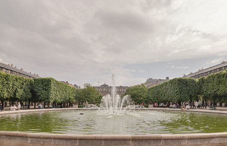 France, Paris - May 03, 2025 - View of Fountain in the Jardin du Palais Royal with the Palais Royal building and sky in the backhground. known as "Fontaines de Pol Bury" use it as your Wallpaper, Poster and Space for text, Selective focus.の写真素材