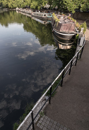 London, UK - Jun 21, 2025 - a picturesque area of Little Venice in West London, It is the junction point of the Grand Union Canal and the Regent's Canal, its tranquil canals and waterways lined with narrowboats and houseboats. use it as your Wallpaper, Poster and Space for text, Selective focus.の写真素材
