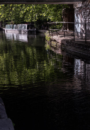 London, UK - Jun 21, 2025 - a picturesque area of Little Venice in West London, It is the junction point of the Grand Union Canal and the Regent's Canal, its tranquil canals and waterways lined with narrowboats and houseboats. use it as your Wallpaper, Poster and Space for text, Selective focus.の写真素材