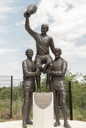 London, UK - Jun 21, 2025 - The World Cup Sculpture or The Champions, The sculpture celebrates the contributions of West Ham United players Bobby Moore, Sir Geoff Hurst, and Martin Peters in England's 1966 FIFA World Cup victory. and it is located in the Queen Elizabeth Olympic Park in Stratford, East London. use it as your Wallpaper, Poster and Copy space, Selective focus.の写真素材
