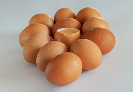 View of Egg yolk in Broken raw chicken eggshell in the among of Fresh chicken egg (Hen egg) on white...