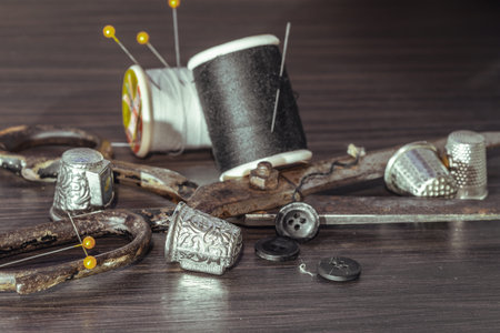 Silver sewing needles, Thimbles, Steel scissors, Measuring tape, Black buttons, Spools of black and...