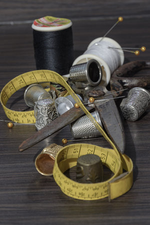 Silver sewing needles, Thimbles, Steel scissors, Measuring tape, Black buttons, Spools of black and...