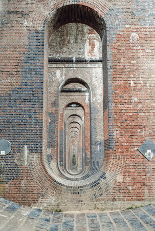 Sussex, UK - May 21, 2025 - The semi-circular arches vaulting supporting brick piers, composed of traditional red bricks topped with smooth limestone and has been described as âthe most elegant viaduct in Britainâ Architectural splendour of Ouse Valley Viaduct or Balcombe Viaduct (Railway viaduct) carries the Brighton Main Line over the River Ouse in Sussex. use it as your Wallpaper, Poster and Copy space, Selective focus.の写真素材