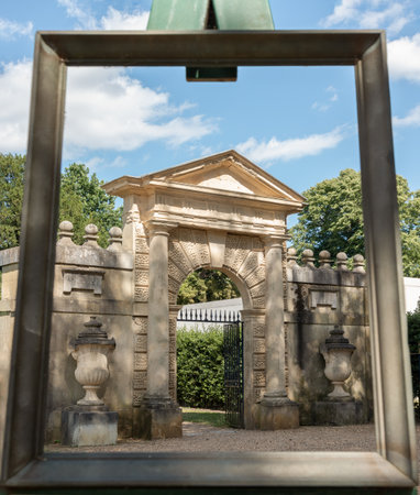 London, UK - Jun 28, 2025 - The large frame aligns with the view of the Inigo Jones Gateway, which is located within the Chiswick House and Gardens. display designed to highlight the architectural features and historical significance of the gateway within its landscape setting, use it as your Wallpaper, Poster and Copy space, Selective focus.の写真素材