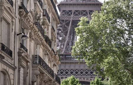 France, Paris - May 03, 2025 - Details of The Majestic Eiffel Tower view between with typical...