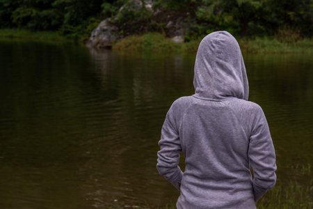 The young woman is standing, watching the beautiful swamps.