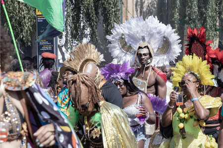 London, UK - Aug 25, 2025 - a performer adorned in a colorful and intricate costume featuring a large, feathered headdress and ornate jewelry at the Notting Hill Carnival in West London, widely recognized for its celebration of Caribbean culture and history, characterized by elaborate parades, music and food.の写真素材